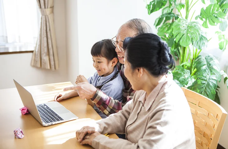 family sitting around laptop