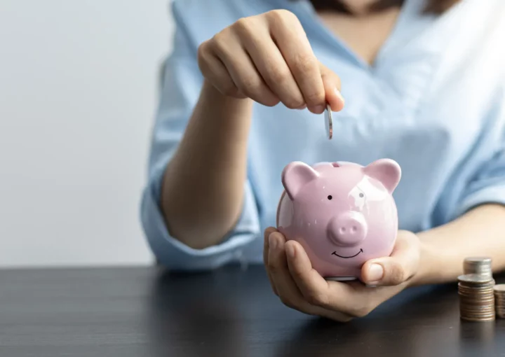Person putting money in piggy bank