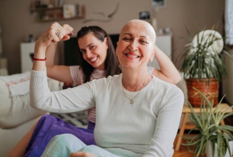 cancer survivor image of woman flexing arm